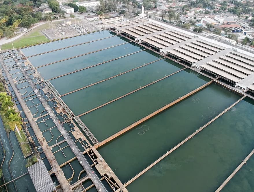 Estrutura de tratamento de água com reservatórios e clarificadores, típica de sistemas de saneamento.