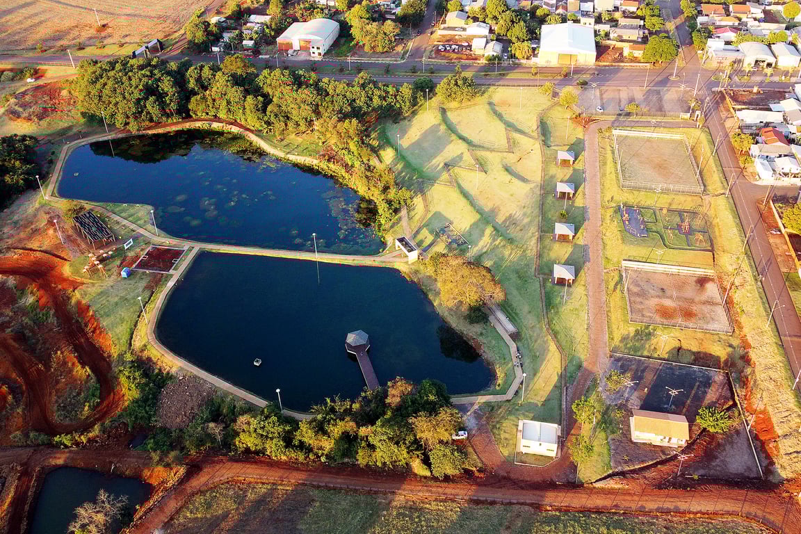 Vista aérea de cidade com lago e áreas verdes no Paraná