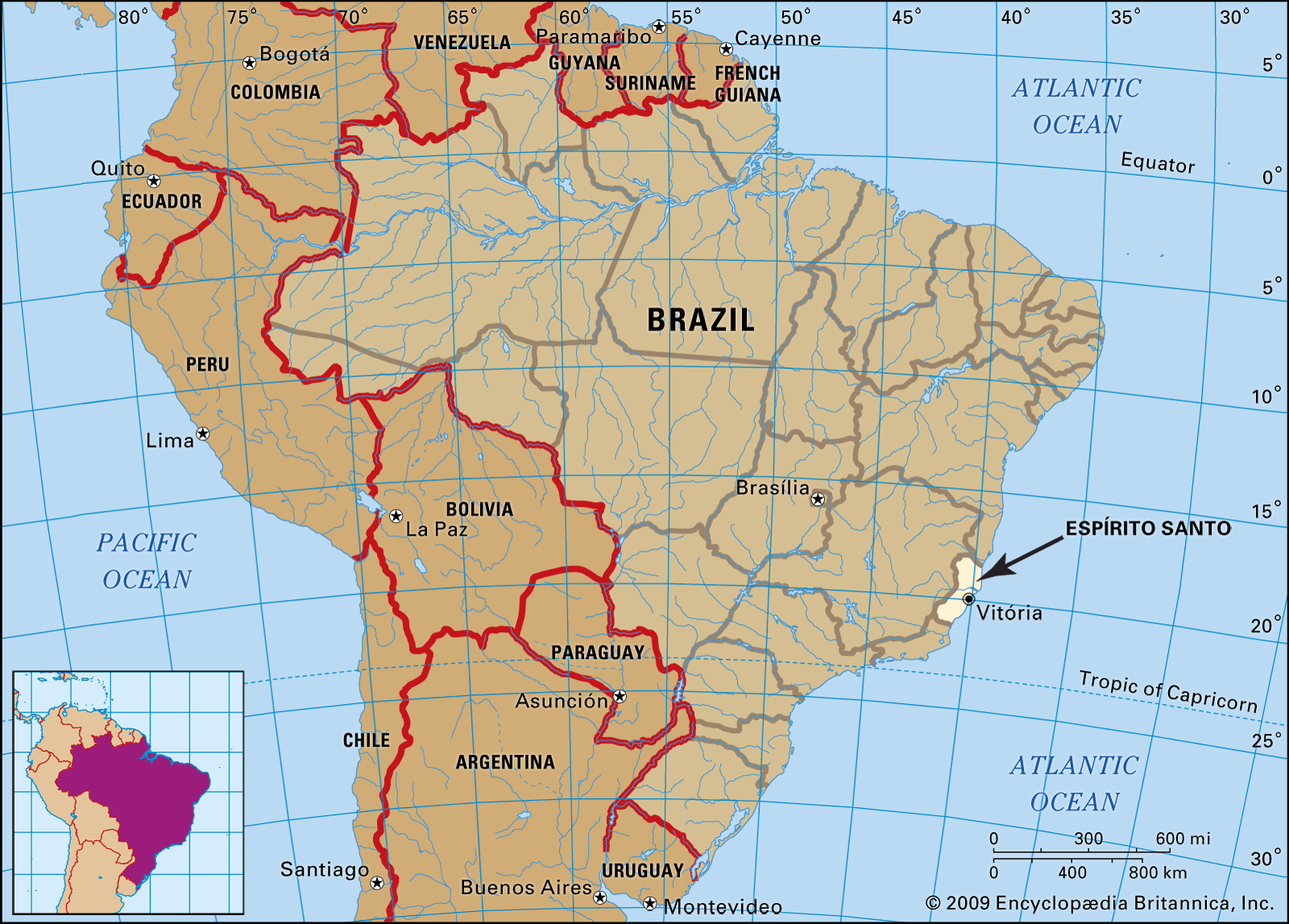 Vista aérea do rio Guandu passando por área urbana no Espírito Santo, com pontes e morros ao fundo.