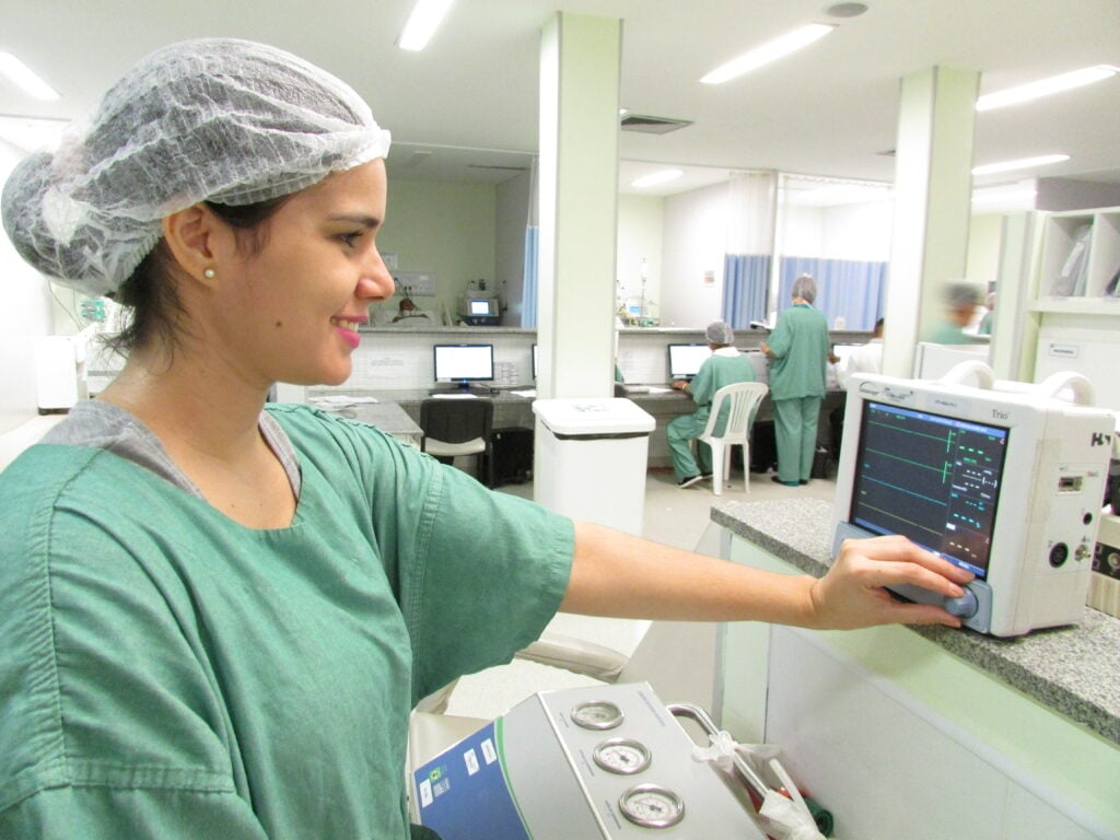 Profissional de saúde em hospital moderno, analisando monitor