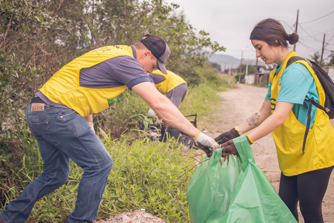 Equipe em ação de limpeza ambiental em área de mangue