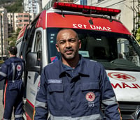 Profissionais do SAMU atuando ao lado de ambulância em ambiente urbano.