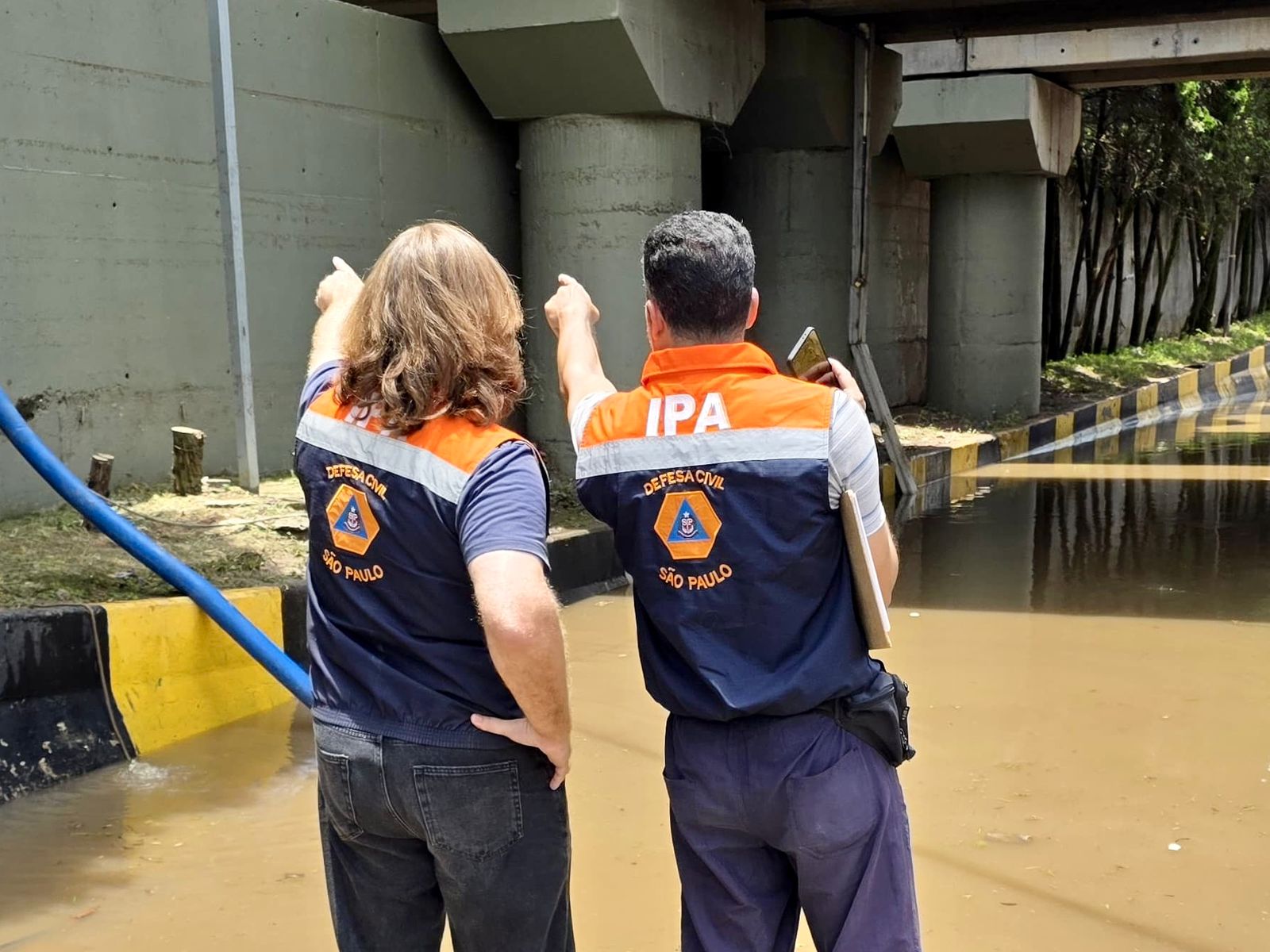 Agentes da Defesa Civil em vistoria de área alagada