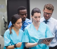 Profissionais de saúde em discussão de prontuário em ambiente hospitalar