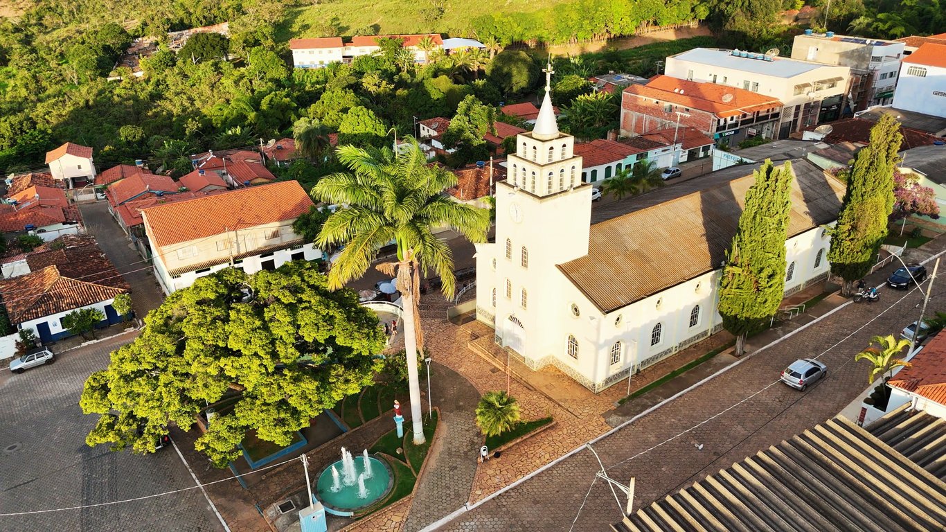 Vista aérea de Carbonita, com praça central, igreja e morros ao fundo