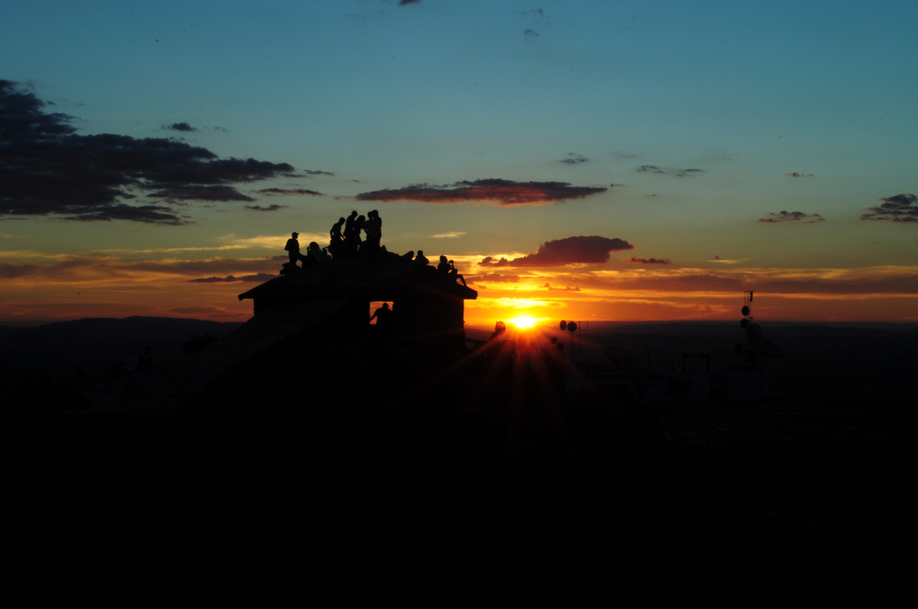 Vista panorâmica de São Thomé das Letras ao pôr do sol, com casas de pedra e morros ao fundo