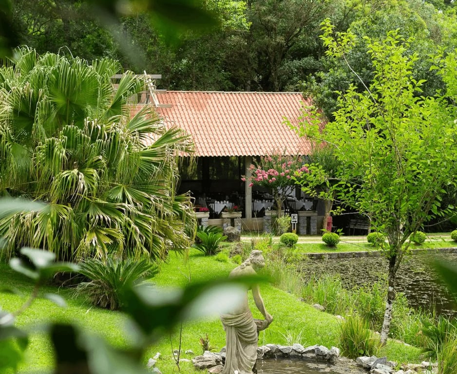 Paisagem rural na Serra dos Tapes, com gramado, lago e gazebo ao entardecer