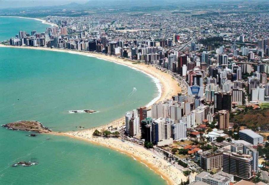 Orla de Anchieta (ES) em dia ensolarado, com prédios e faixa de areia