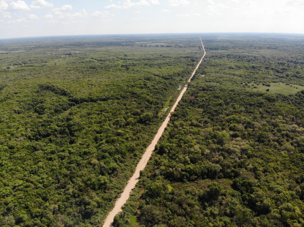 Portal da Transpantaneira, estrada de terra e paisagem pantaneira ao fundo