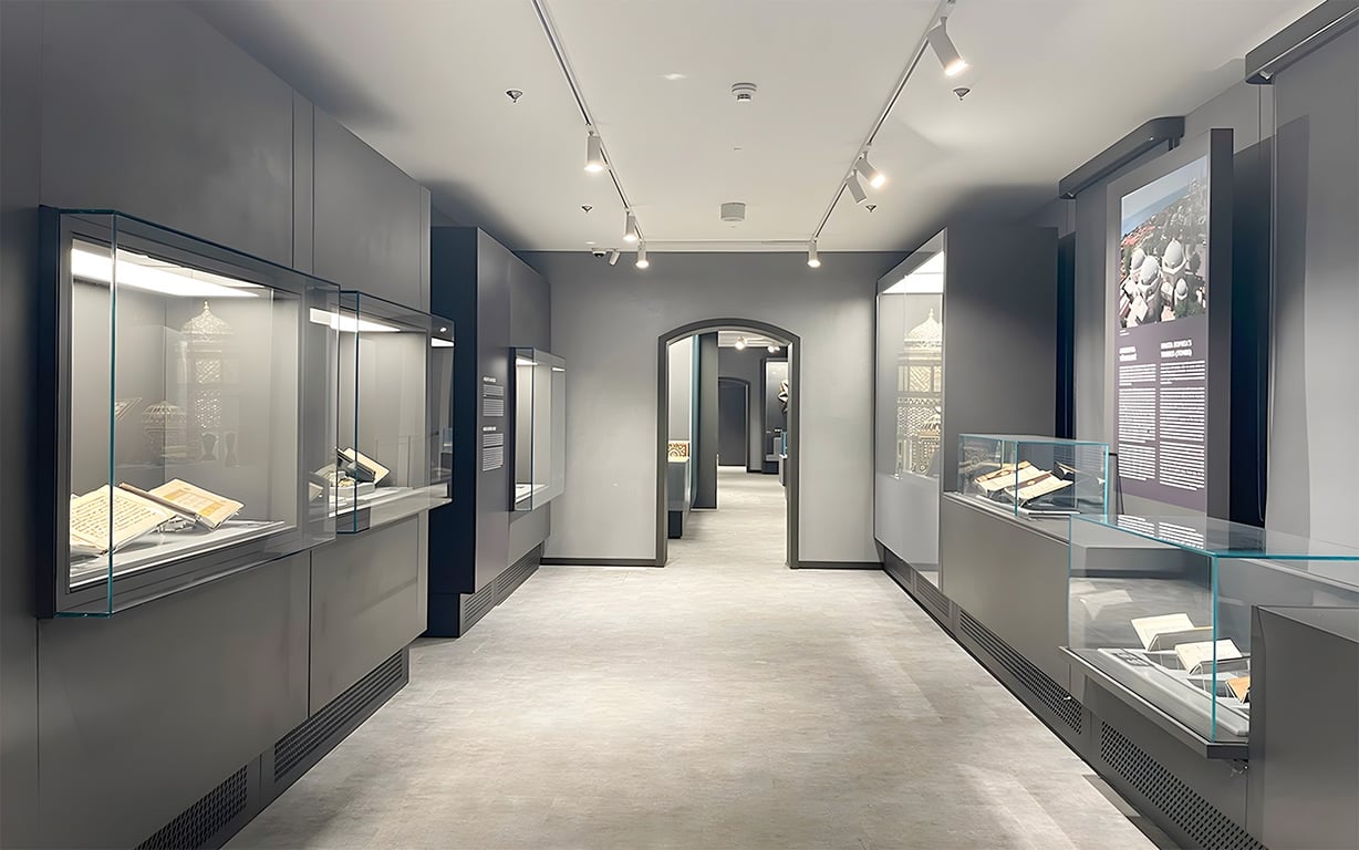 Interior de museu histórico, com vitrines de exposição e objetos culturais