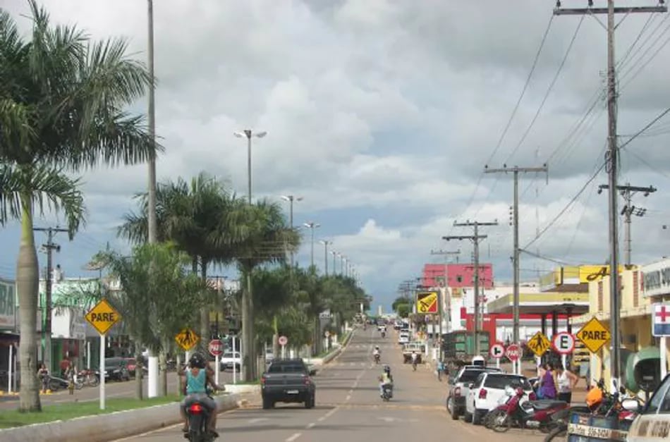 Avenida no centro de Juara MT em dia claro, com tráfego e comércios locais