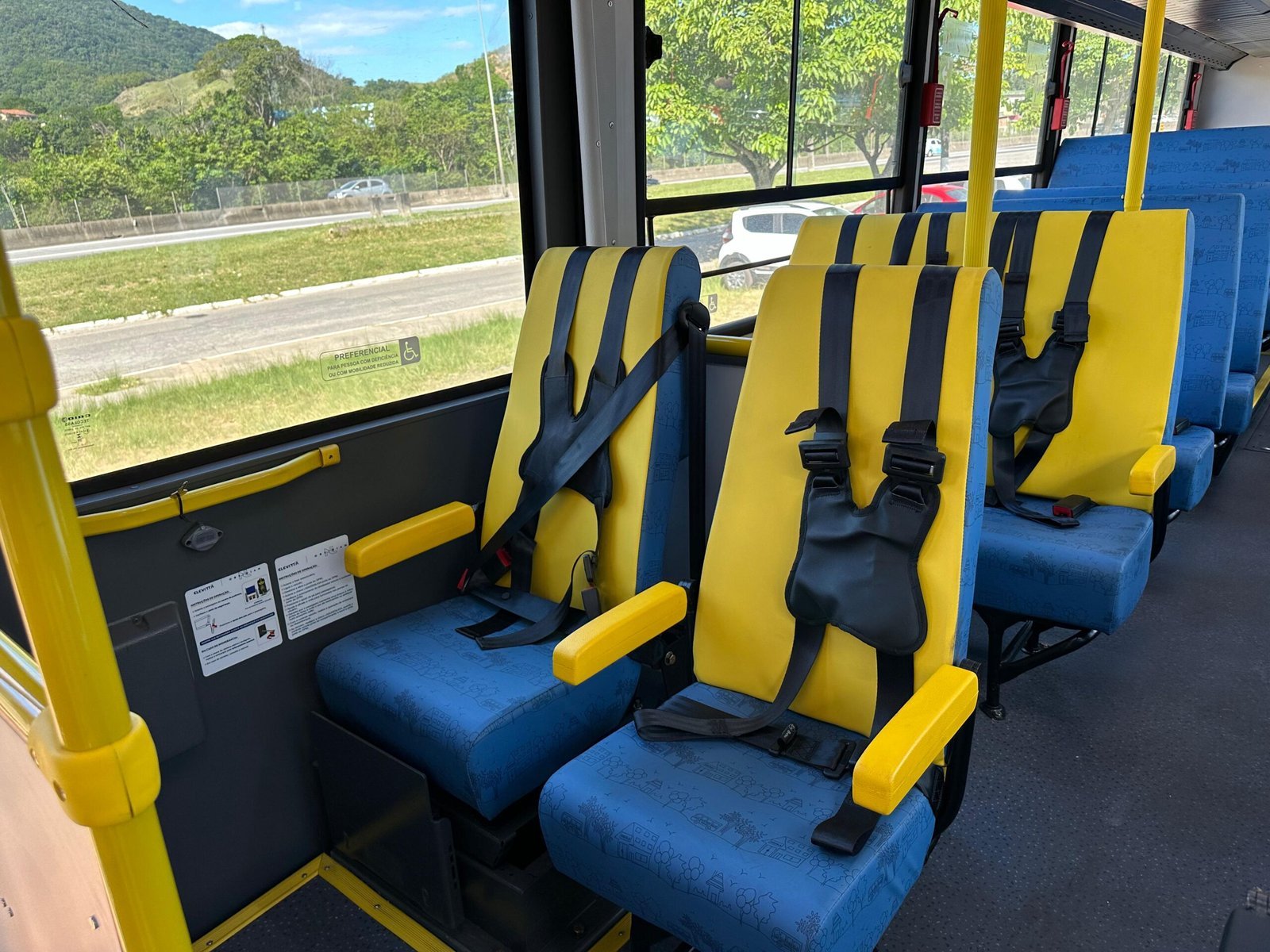Interior de ônibus escolar com cintos de segurança