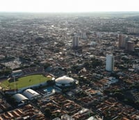 Vista aérea de Araçatuba SP ao entardecer, mostrando prédios e áreas verdes.