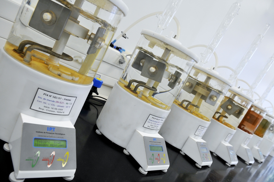 Ambiente de laboratório de materiais com equipamentos de ensaio e amostras metálicas