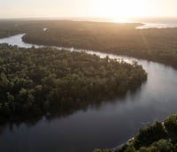 Amazônia, rio e floresta ao pôr do sol, sugerindo a logística em áreas remotas de Iracema RR.