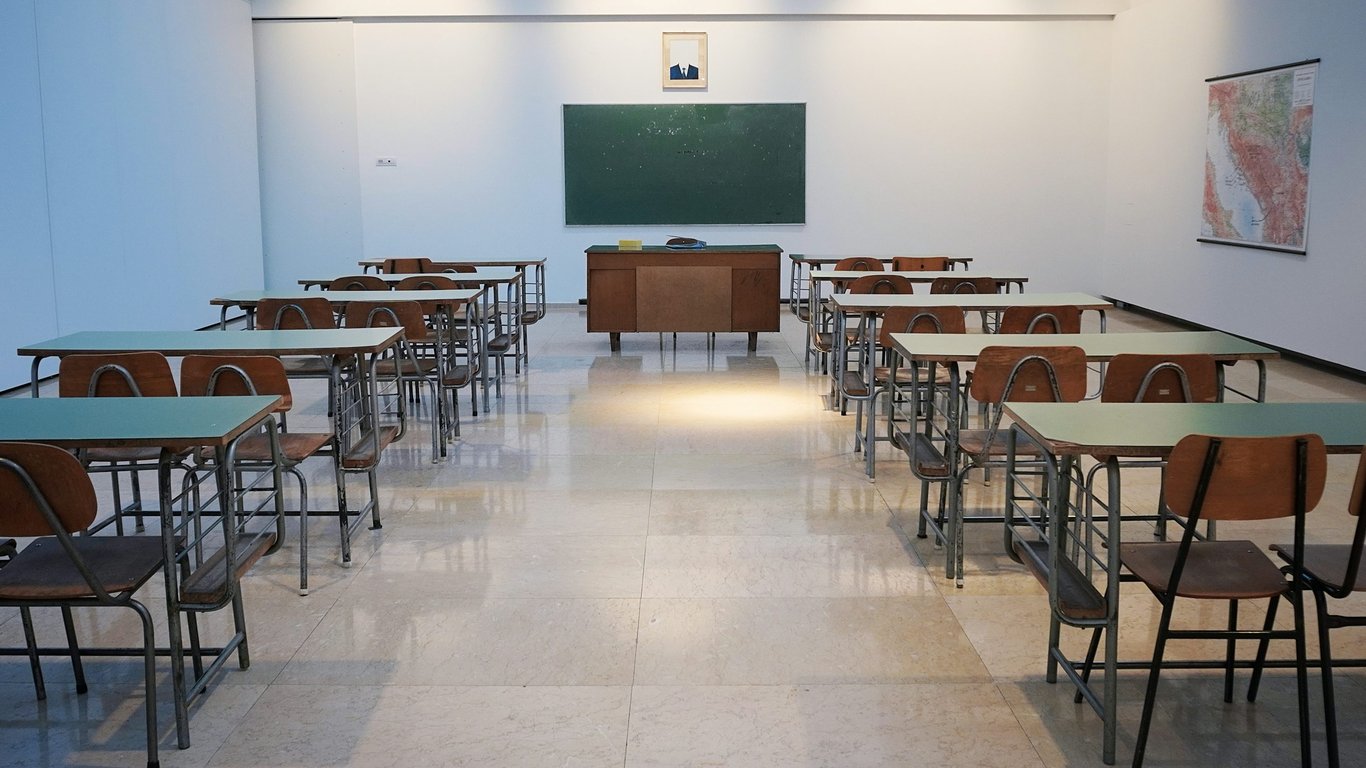 Sala de aula universitária moderna, com projetor e carteiras organizadas