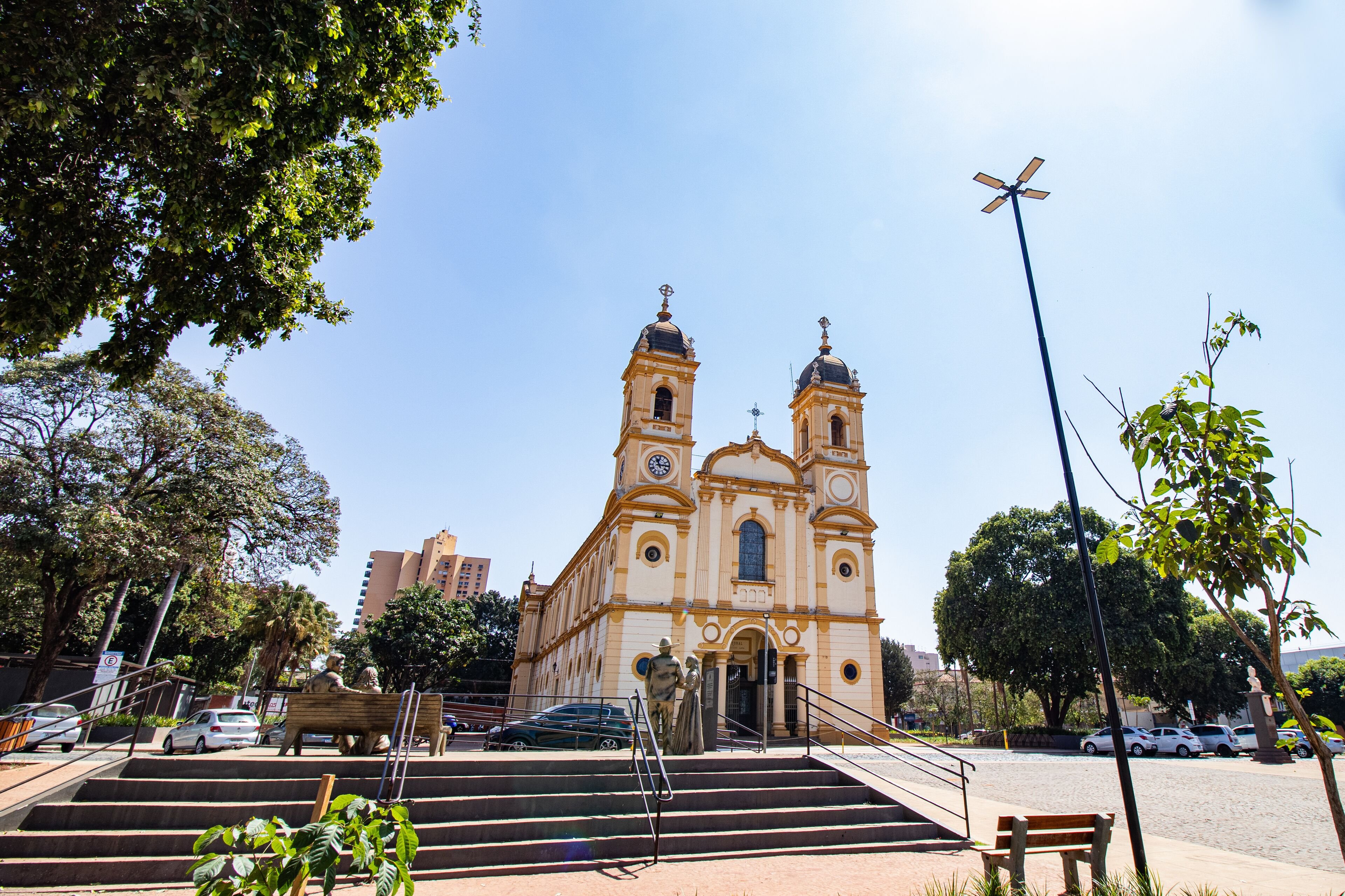 Praça e igreja em cidade do interior paulista, céu azul e área arborizada