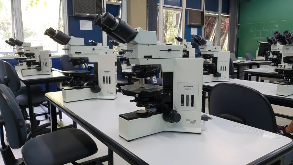 Laboratório de geociências com microscópios e amostras de rochas
