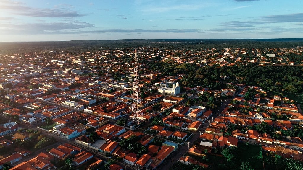 Vista aérea de cidade do interior do Piauí, com casas térreas e vegetação, em dia ensolarado