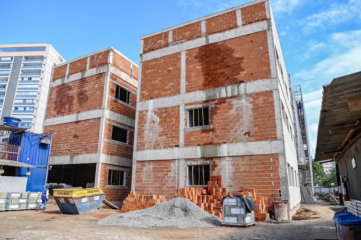 Canteiro de obras urbano com materiais e estruturas, simbolizando frentes de serviços municipais