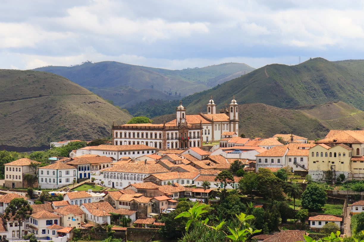 Paisagem urbana de cidade do interior de Minas Gerais, com praça e igreja ao fundo