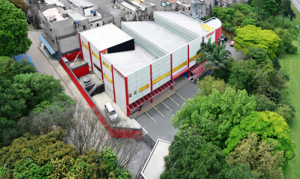 Imagem aérea da região de Restinga (SP) ao entardecer, com áreas verdes e perfil urbano de cidade do interior