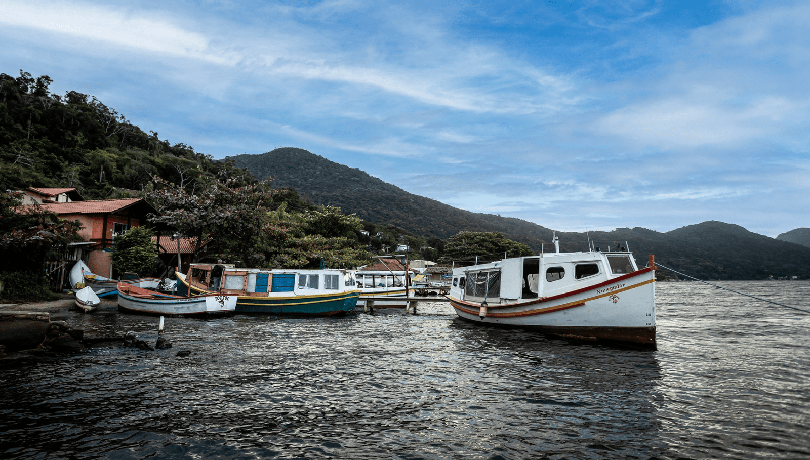 Paisagem urbana de Florianópolis, com barcos e morros ao fundo