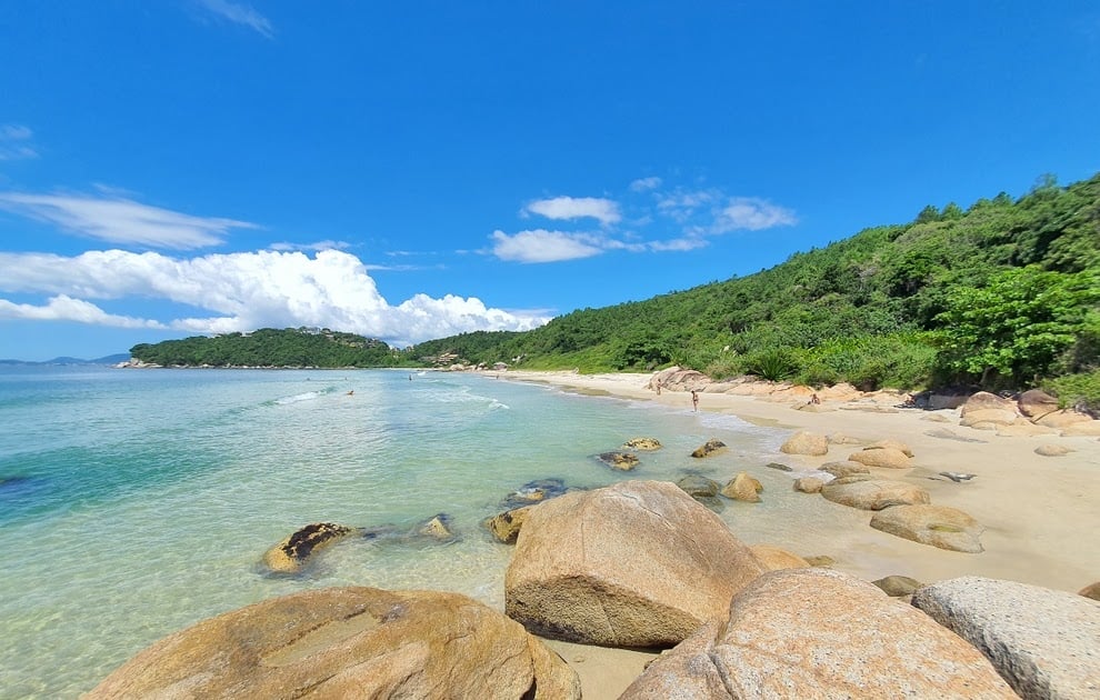 Praia de Governador Celso Ramos, mar azul e costões ao fundo