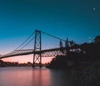 Vista aérea da Ponte Hercílio Luz ao entardecer, cartão-postal de Florianópolis.