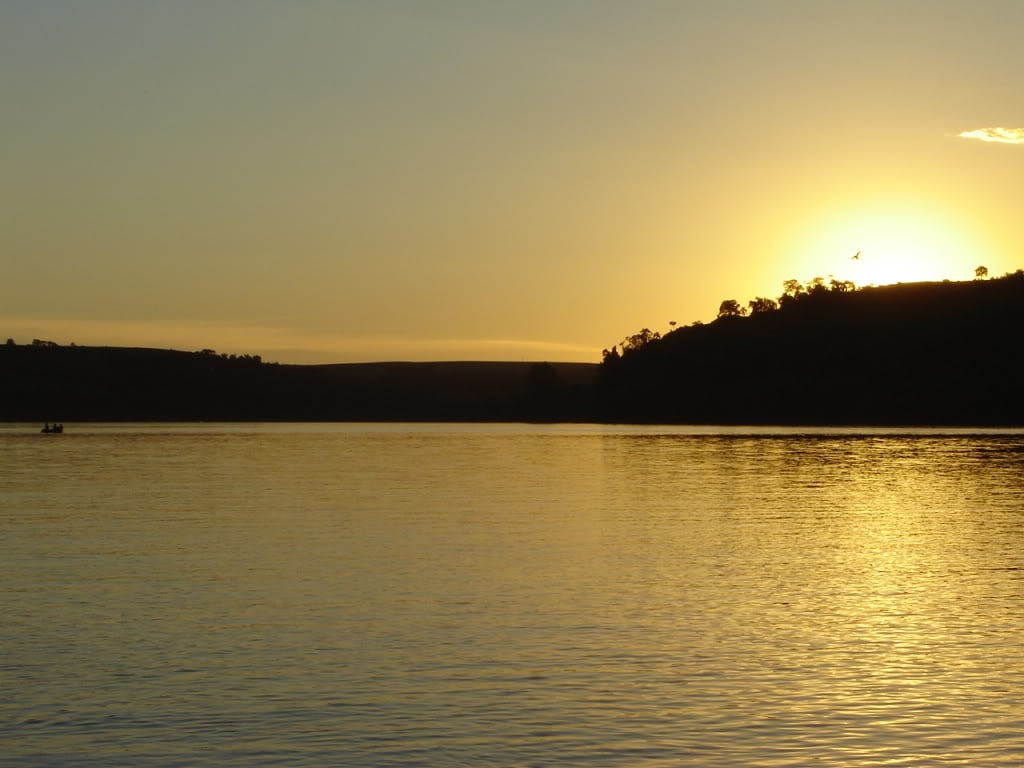 Paisagem rural no Noroeste do Rio Grande do Sul, com campos e lago ao pôr do sol