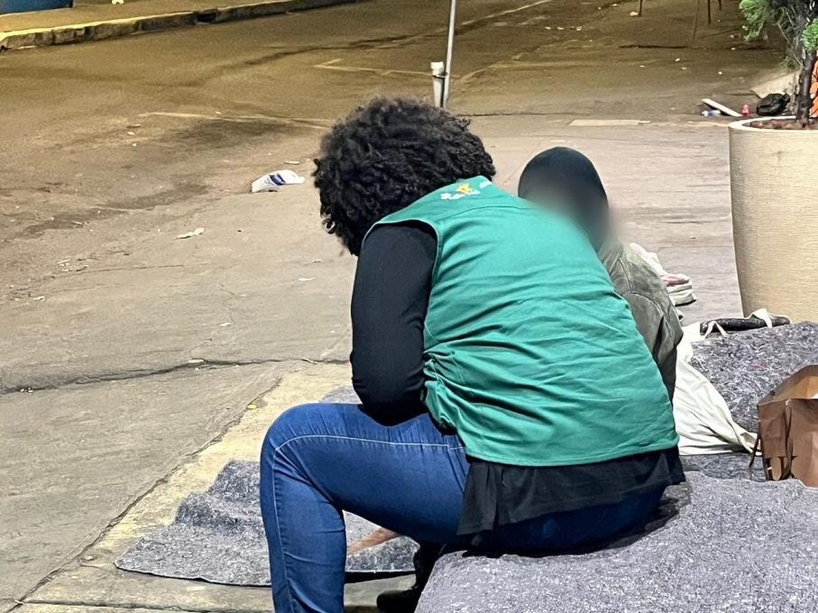 Profissionais de assistência social dialogando com pessoa em vulnerabilidade em área urbana