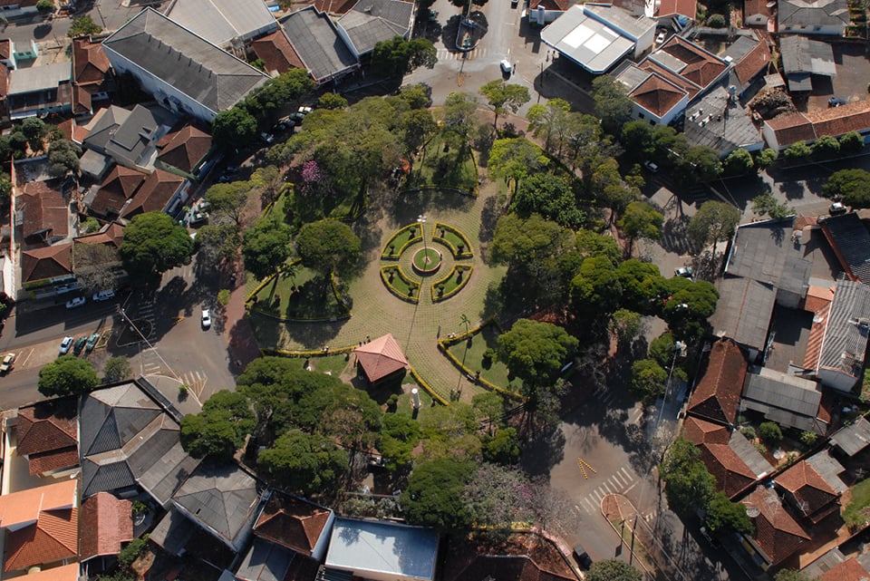 Vista aérea de cidade do Norte Pioneiro do Paraná, com praça central arborizada e entorno urbano