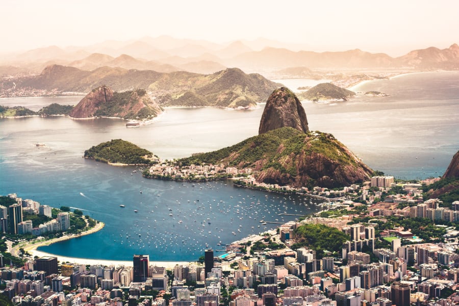 Vista aérea do Rio de Janeiro com vias urbanas e a Baía de Guanabara ao fundo
