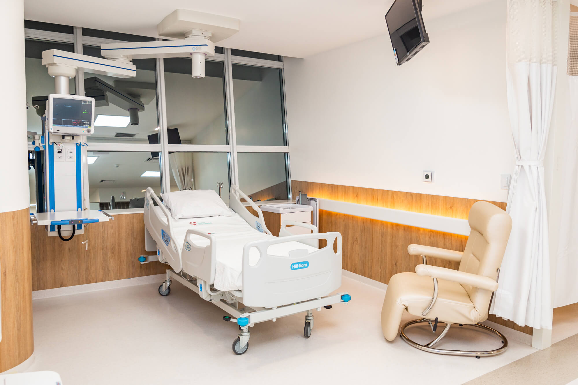 Ambiente hospitalar moderno, com leito e equipamentos, em composição horizontal
