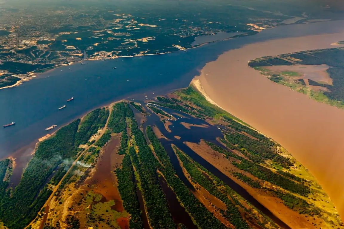 Vista aérea do Encontro das Águas em Manaus AM, com o skyline da cidade ao fundo