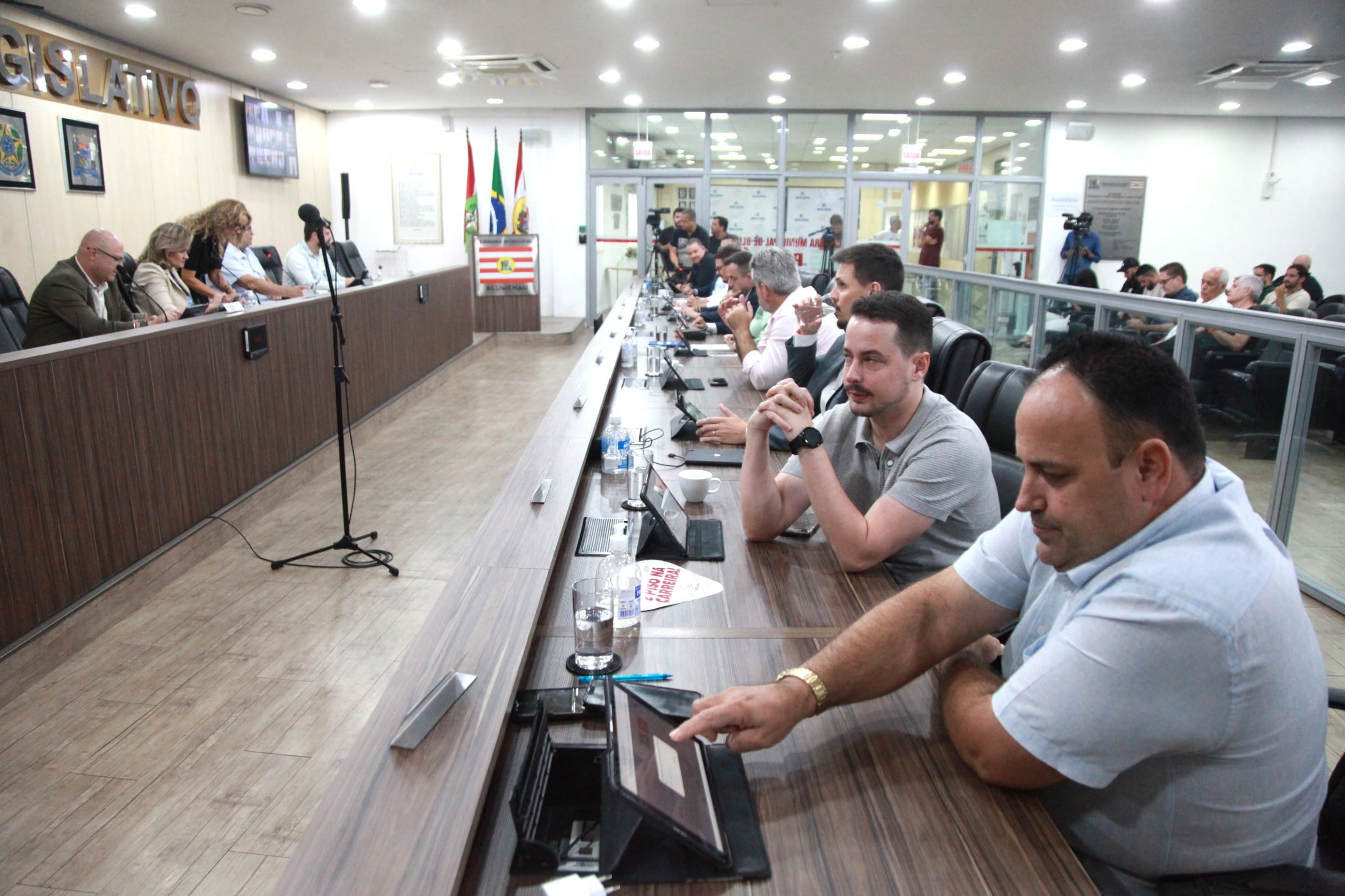 Ambiente administrativo público, pessoas em reunião de trabalho, composição horizontal