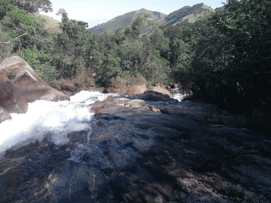Paisagem rural do Meio-Oeste catarinense, com rio, mata e morros ao fundo; composição horizontal