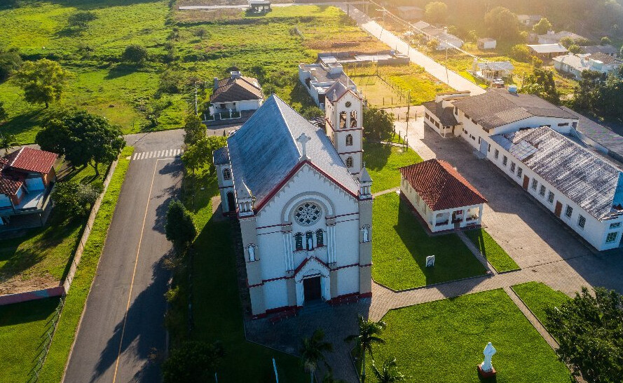 Vista aérea de cidade com igreja e áreas verdes ao redor