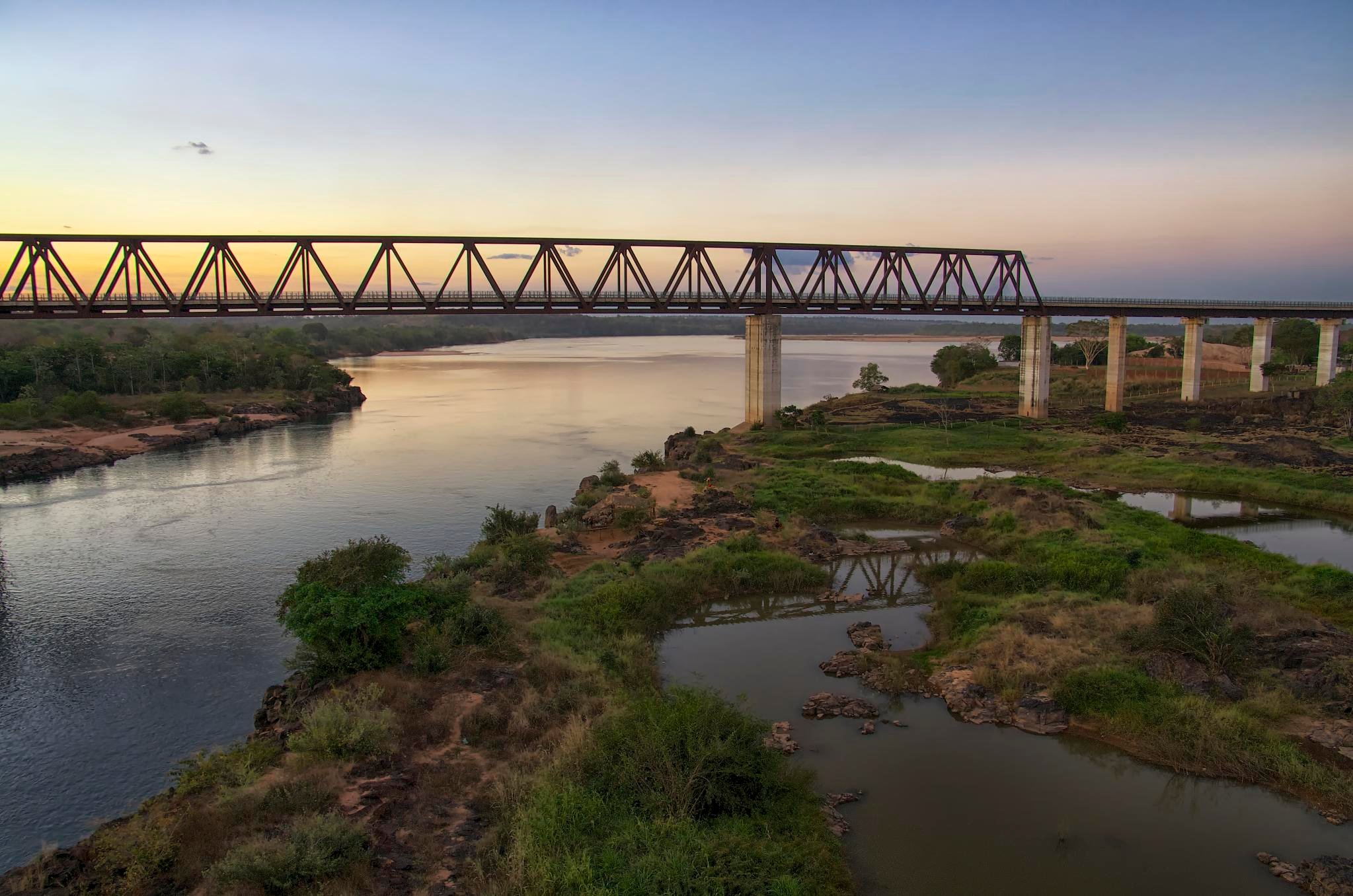 Vista aérea do rio Tocantins ao entardecer, com ponte rodoviária ao fundo