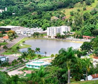 Paisagem urbana de cidade pequena com morros e lago em Santa Catarina, semelhante a Lindóia do Sul SC