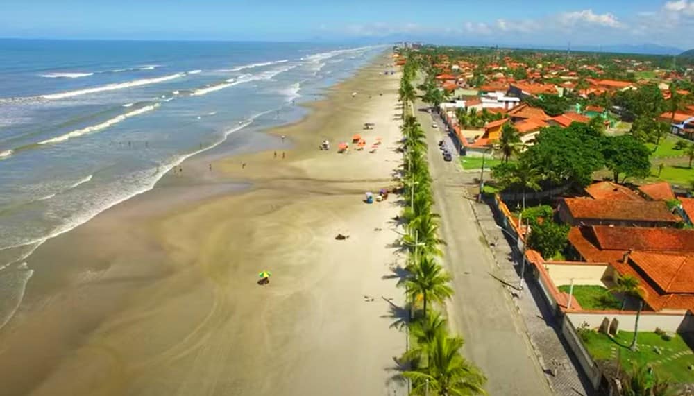 Orla de Mongaguá com praia e área urbana ao fundo