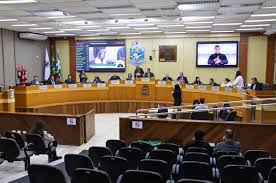 Plenário de uma câmara municipal brasileira, com cadeiras e microfones organizados para sessão legislativa