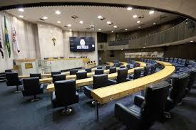 Plenário de uma câmara municipal brasileira, com cadeiras e mesa diretora, em orientação horizontal.