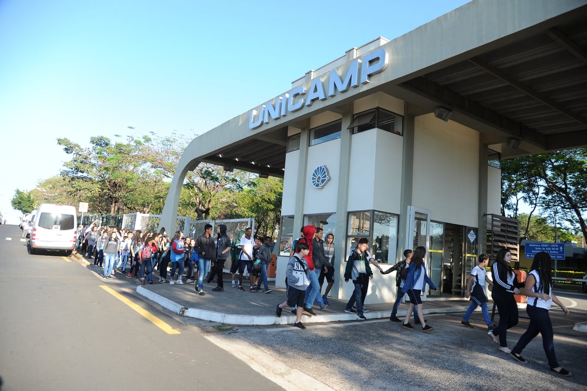 Entrada do campus da Unicamp, pessoas circulando em um dia claro