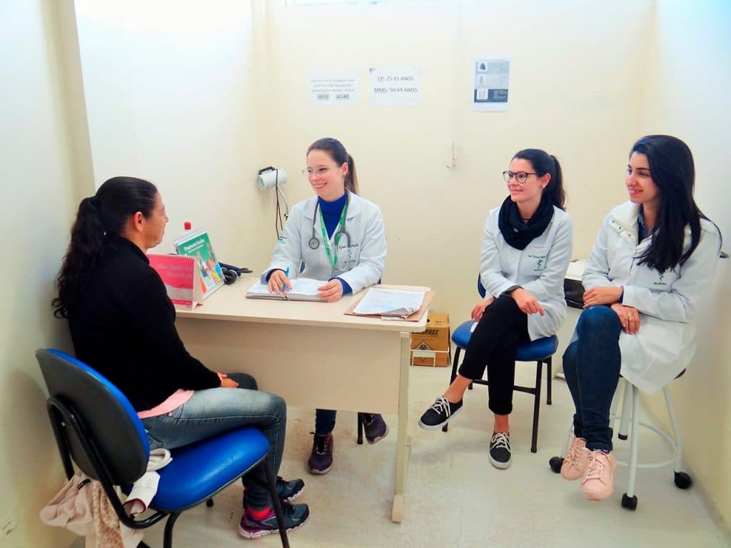 Profissional de saúde realizando orientação em unidade básica de saúde