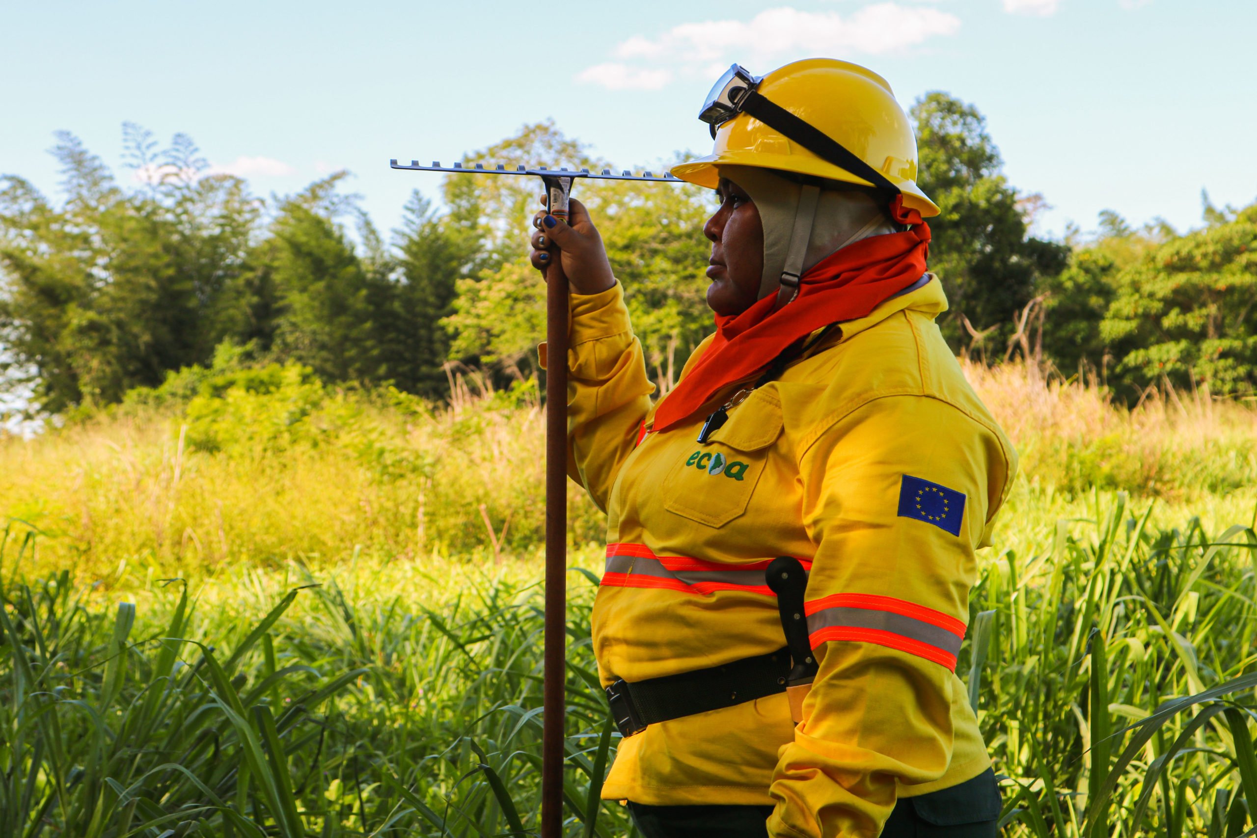 Brigadista em ação no Cerrado, com EPI e ferramenta de combate a incêndio