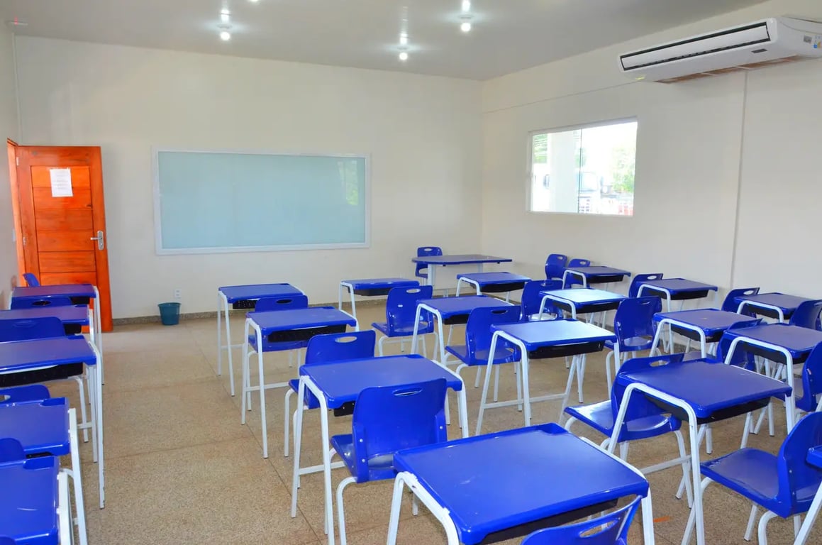 Sala de aula pública, carteiras organizadas, lousa e iluminação natural