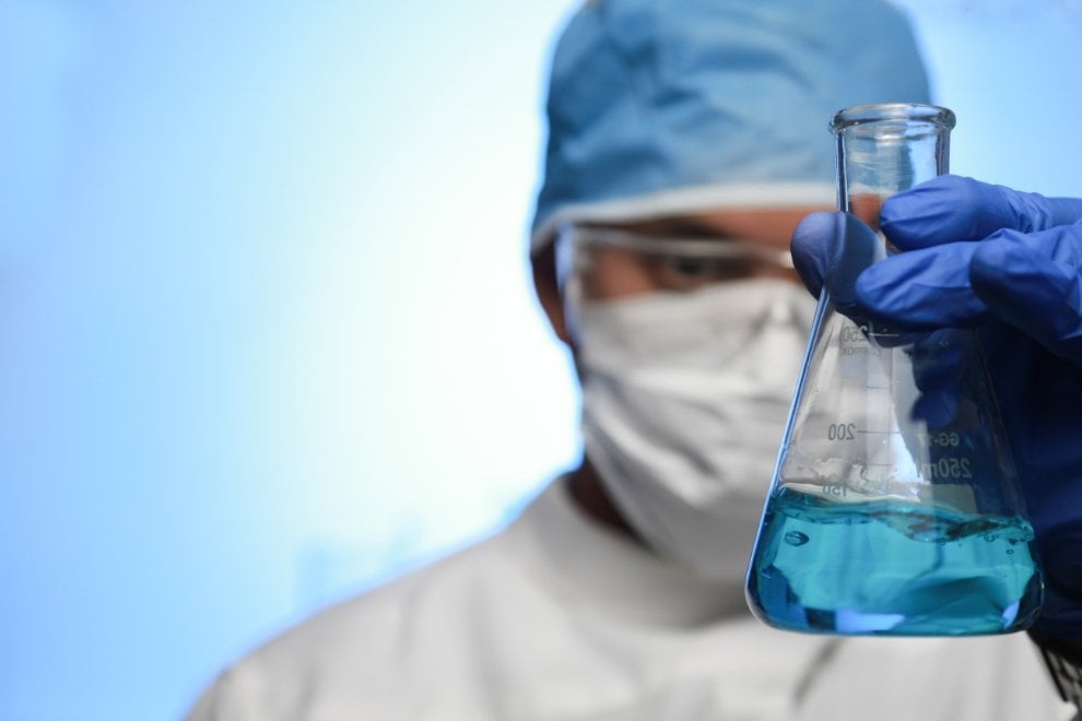 Profissional de saúde em laboratório manipulando amostras e equipamentos