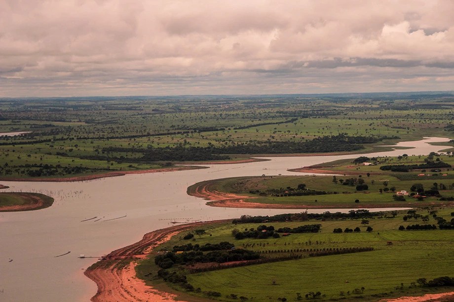 Vista aérea do rio e vegetação na região de Ilha Solteira ao pôr do sol
