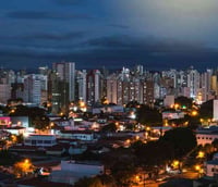Horizonte urbano de Campinas ao entardecer, com prédios e áreas verdes ao fundo